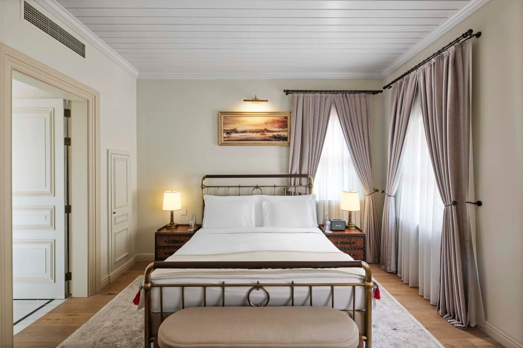 Elegantes Schlafzimmer mit Kingsize-Bett und sanfter Beleuchtung in der Courtyard Suite.