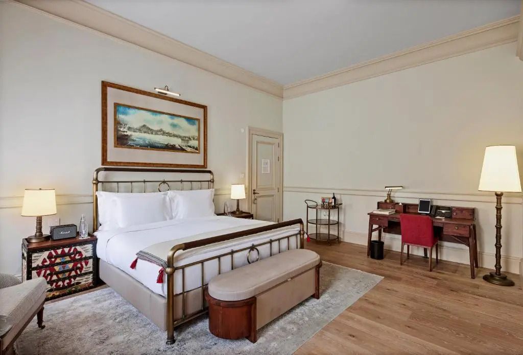 Comfortable Deluxe Doppelzimmer mit großem Bett und Kunstwerk an der Wand.