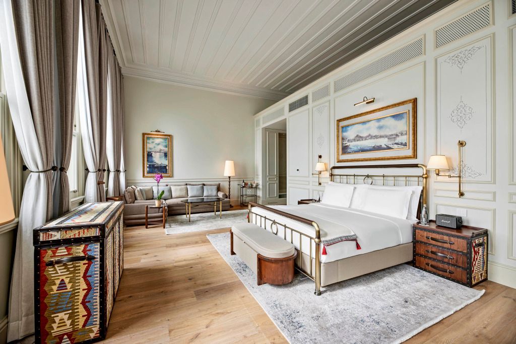 Junior-Suite mit luxuriösem Bett und stilvoller Einrichtung mit Kunstwerken