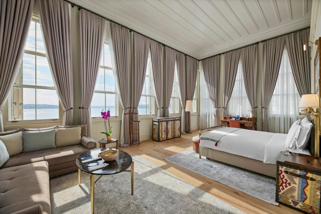 Helles Zimmer mit großen Fenstern und stilvollen Möbeln sowie Fensterblick