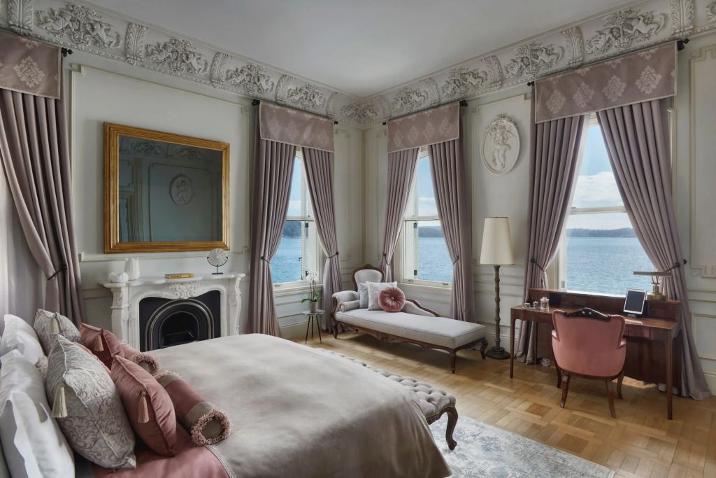 Elegante Suite mit großen Fenstern, klassischen Möbeln und Blick aufs Wasser