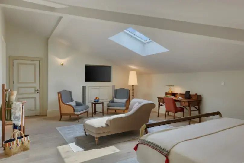 Helles Dachzimmer im Sky Loft mit gemütlichen Sitzmöbeln und einem Arbeitsbereich.