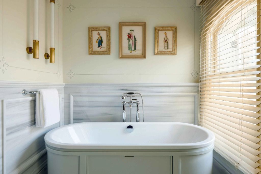 Luxuriöses Badezimmer mit freistehender Badewanne und stilvollen Kunstwerken