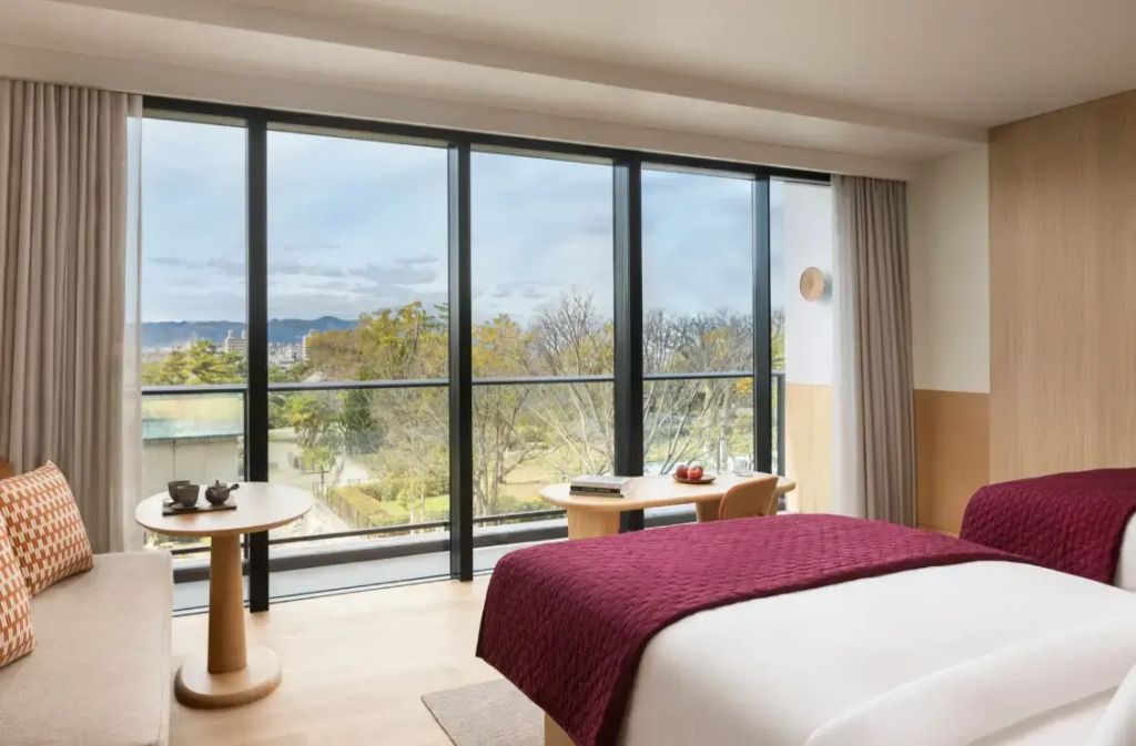 Suite mit großem Fenster und Ausblick auf eine grüne Landschaft vor blauem Himmel