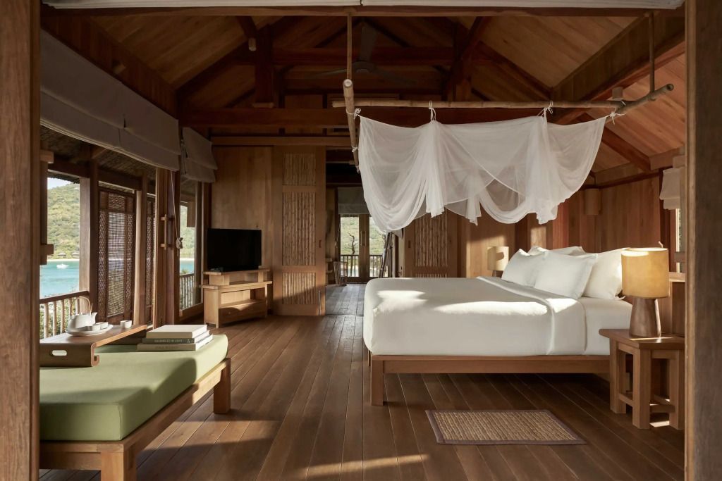Luxuriöses Schlafzimmer mit Holzdecken und großen Fenstern, Blick auf die Umgebung