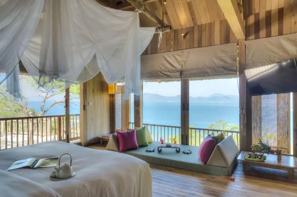 Gemütliches Schlafzimmer mit Panoramablick auf das Meer und stilvollen Details