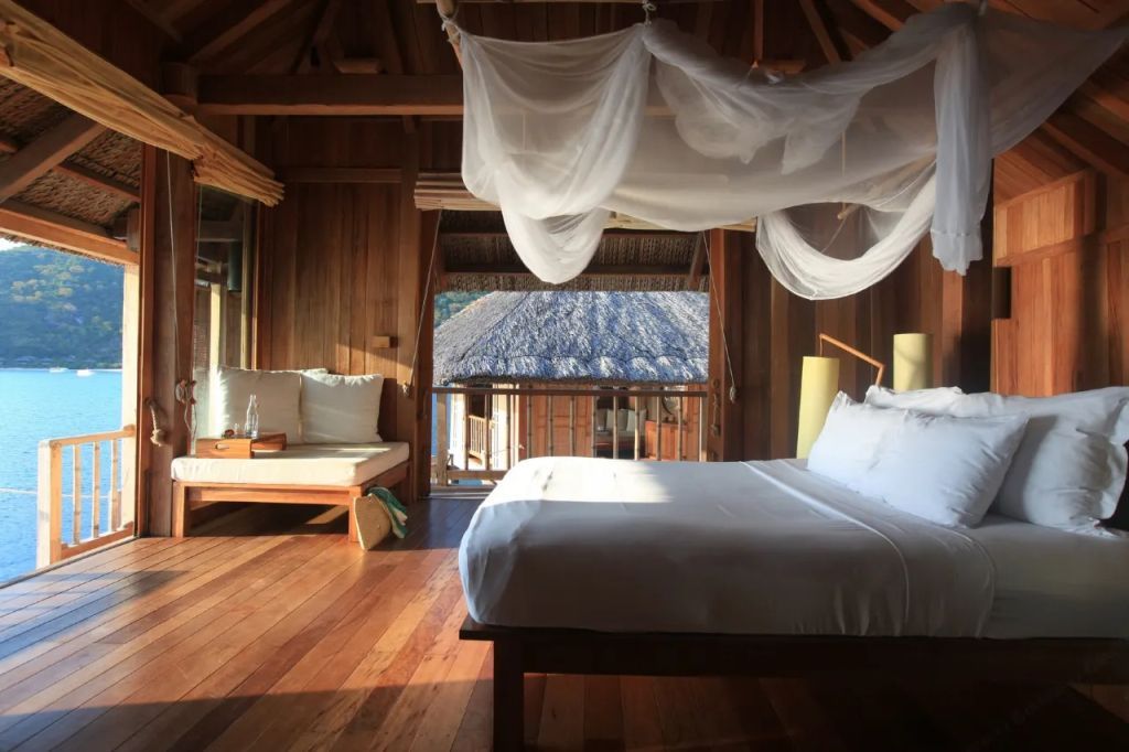 Holzinterieur der Water Pool Villa mit Himmelbett und Blick auf das Dach.