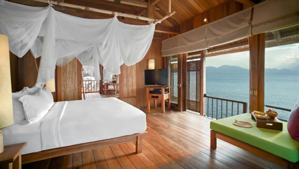 Lichtdurchflutetes Schlafzimmer der Villa mit Meerblick und Holzinterieur.