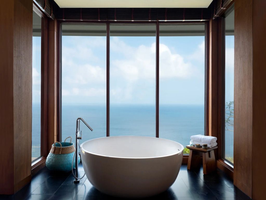 Freistehende Badewanne mit spektakulärem Meerblick durch große Fenster in der Villa.