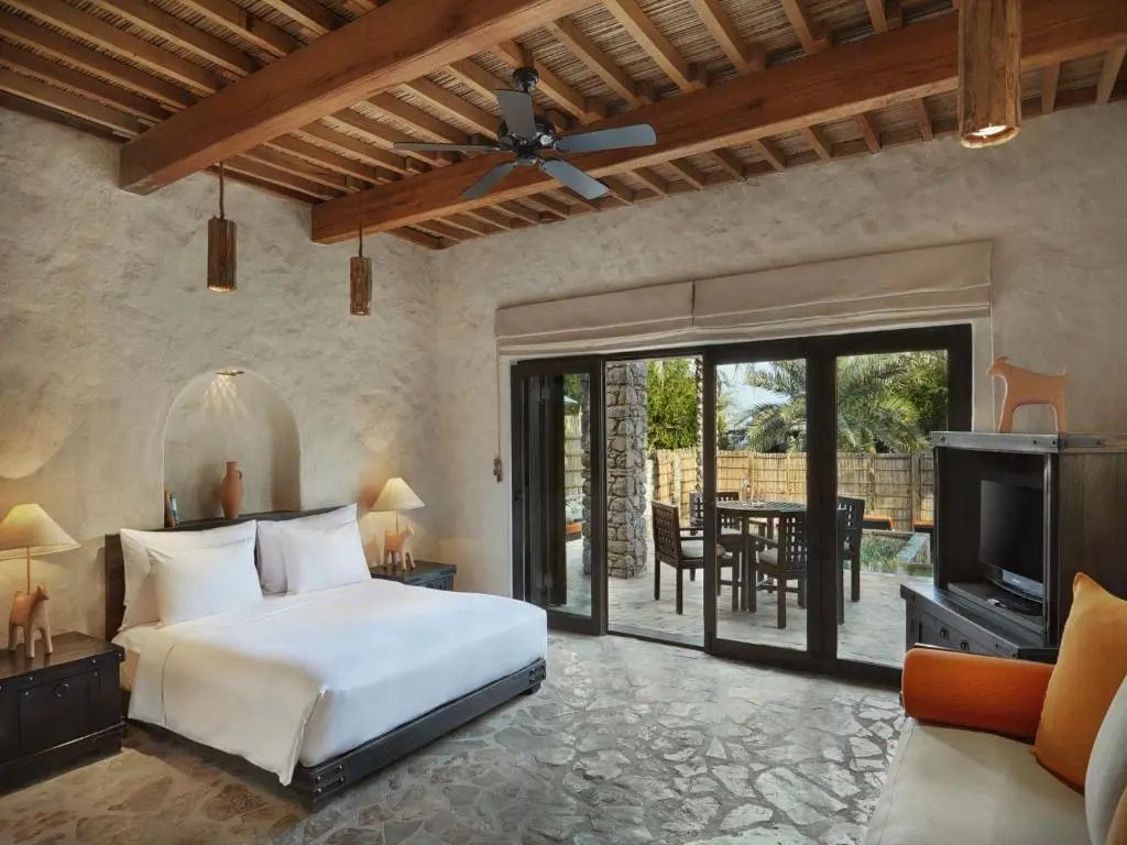 Geräumiges Schlafzimmer in Villa mit Natursteinböden und Holzbalkendecke