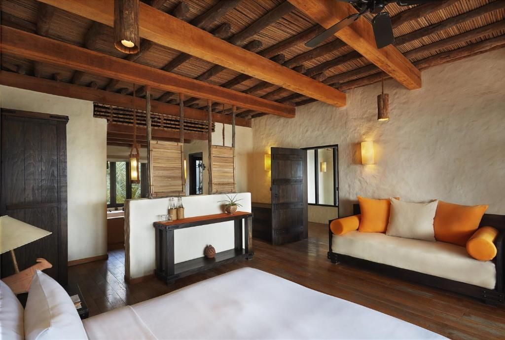 Elegantes Zimmer mit Holzbalkendecke und gemütlicher Sitzecke in der Pool Villa Suite