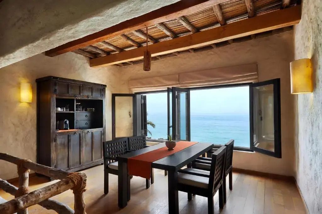 Essbereich mit offenem Fenster und Blick aufs Meer in der Pool Villa Suite