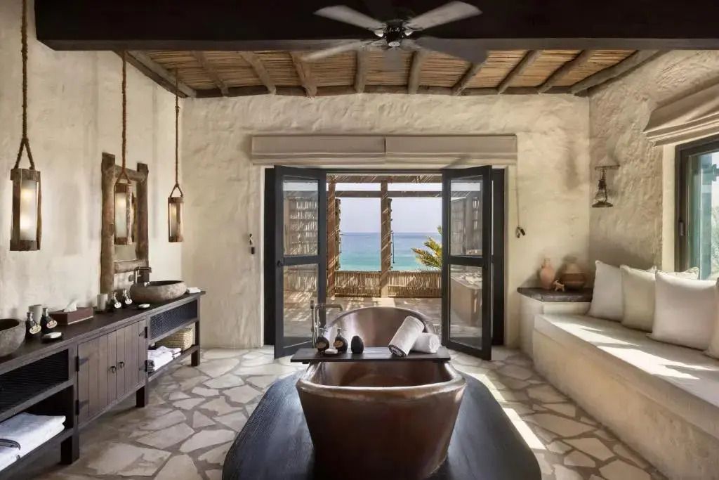 Exklusives Badezimmer mit freistehender Kupferbadewanne und Meerblick
