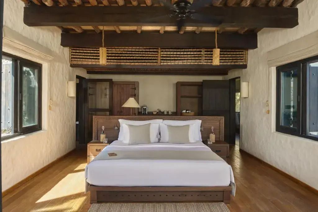 Luxuriöses Schlafzimmer mit einem großen Doppelbett und Holzbalkendecke