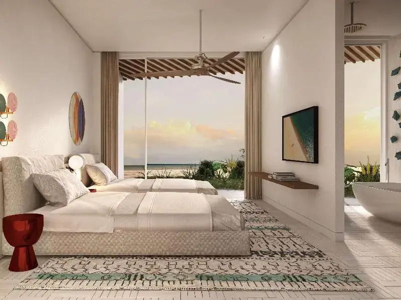 Helles Schlafzimmer mit zwei Betten und Meerblick in der Junior-Suite