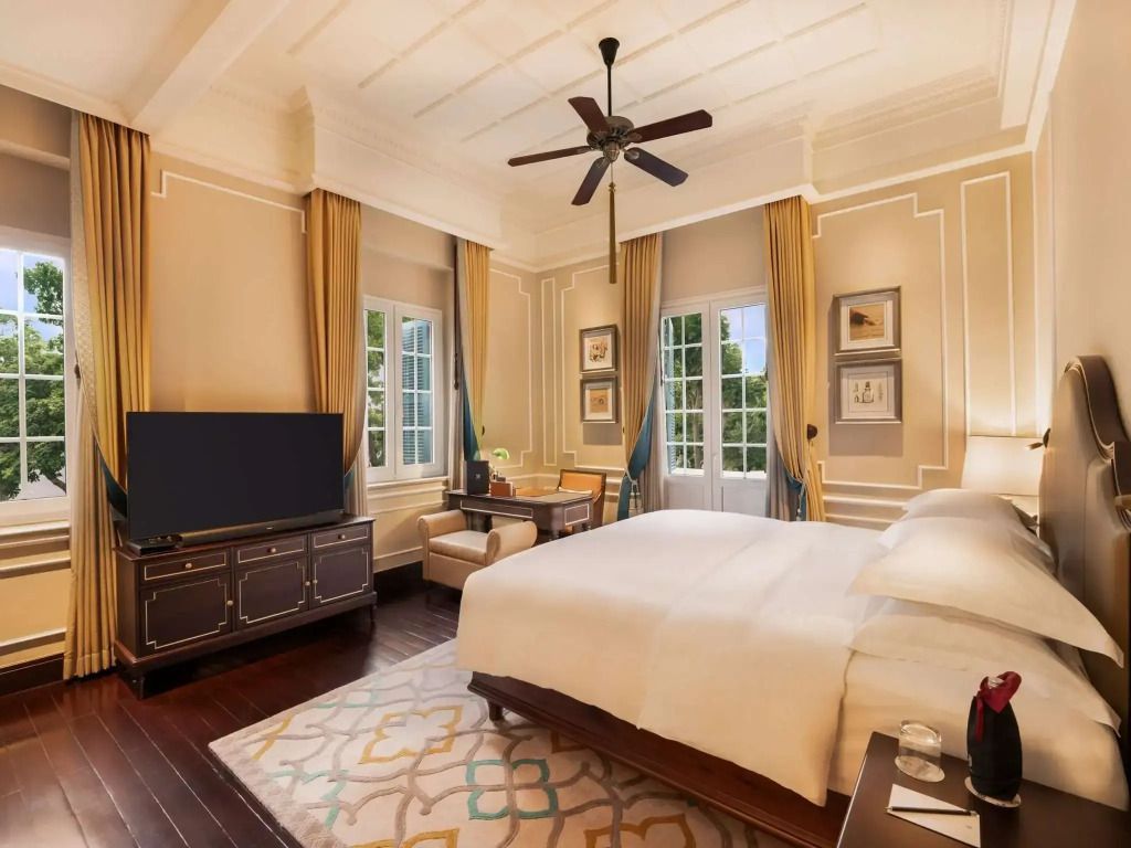 Helles Schlafzimmer mit großem Doppelbett und luxuriösem Dekor in der Graham Greene Suite