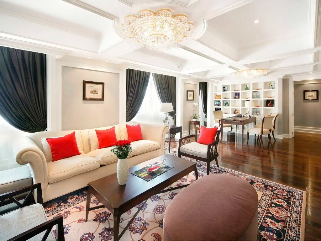 Heller Wohnbereich der Suite mit stilvoller Dekoration und opulentem Kronleuchter.