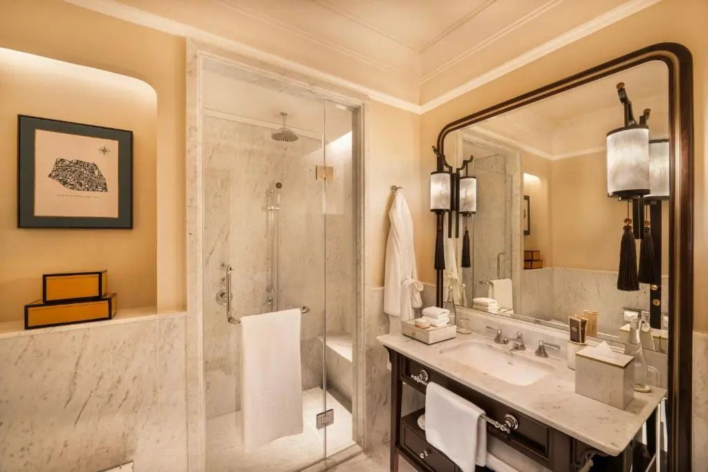 Helles Badezimmer mit Regendusche und Marmorelementen im Sofitel Legend Metropole Hanoi