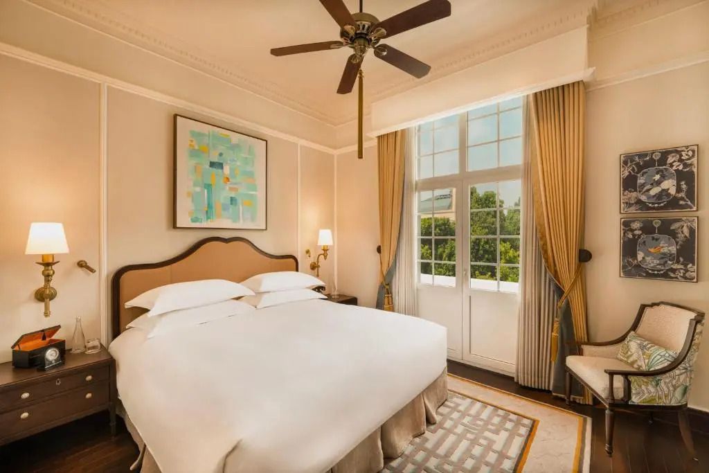 Elegantes Schlafzimmer mit Doppelbett, Deckenventilator und großem Fensterblick.
