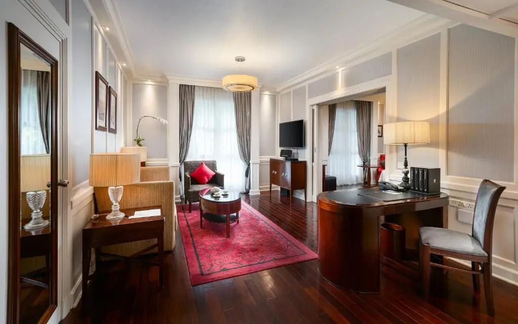 Geräumiges Wohnzimmer mit eleganter Einrichtung und dunklem Holzboden.