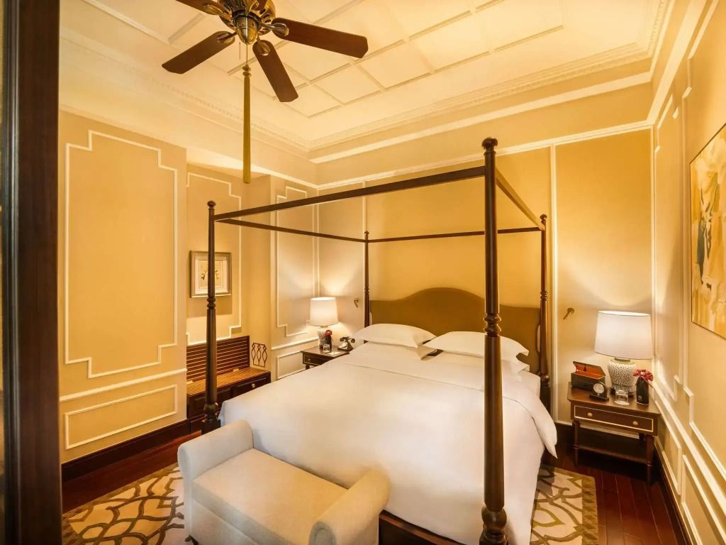 Elegantes Schlafzimmer mit Himmelbett und warmen Farbtönen in der Somerset Maugham Suite.