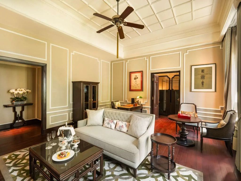 Sitzbereich der Somerset Maugham Suite mit Sofa, Tisch und stilvoller Dekoration.