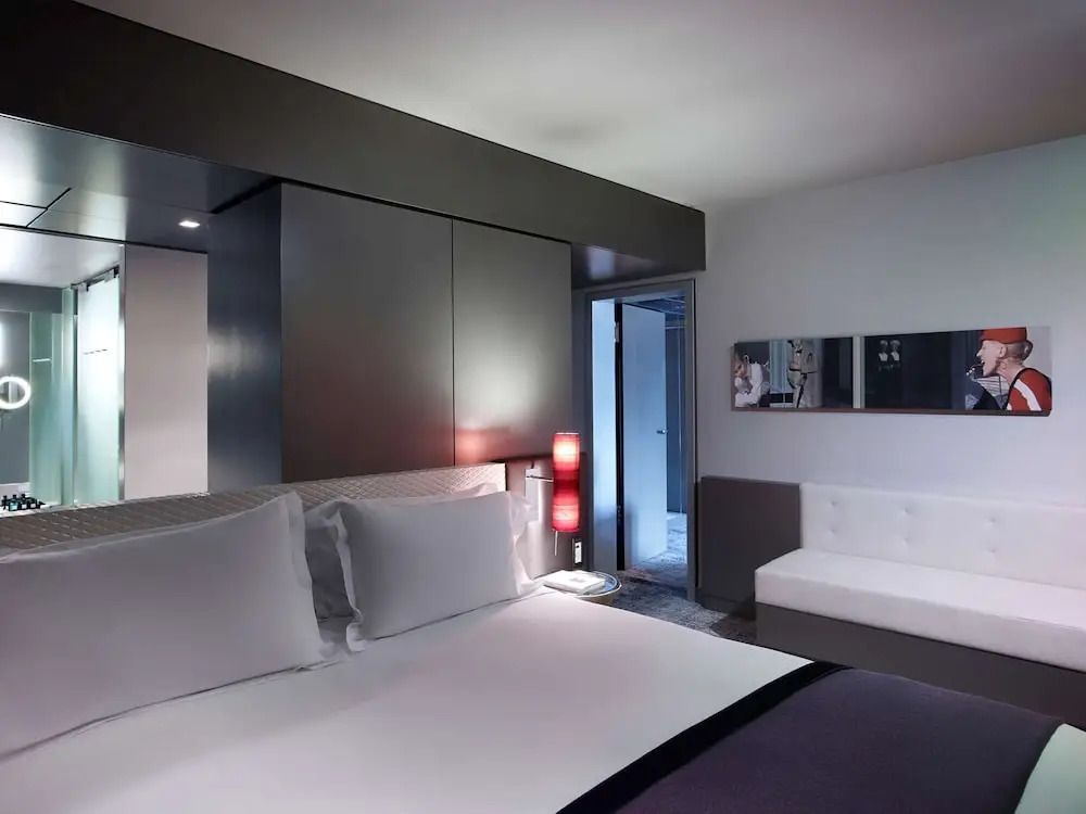 Modernes Doppelzimmer mit schlichter Einrichtung und Kunst an der Wand.