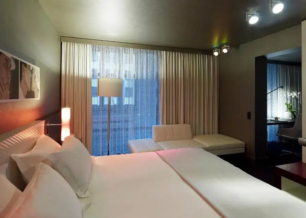 Modernes Doppelzimmer mit großem Fenster und eleganter Einrichtung