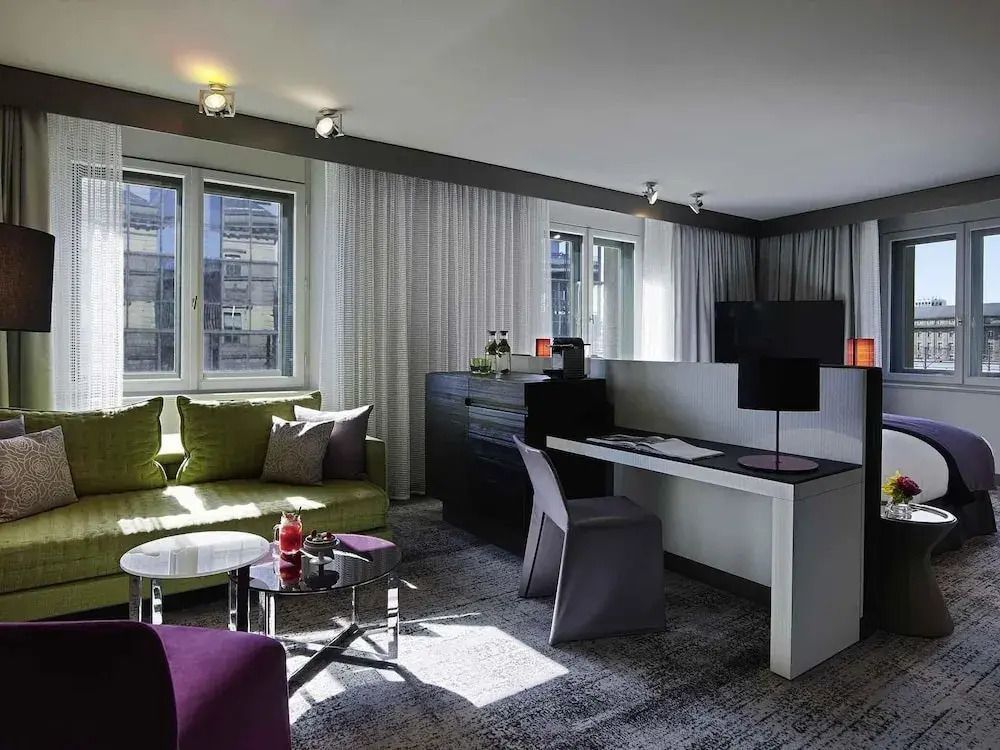 Moderne Junior-Suite mit Schreibtisch und heller Sitzecke im Sofitel Munich Bayerpost