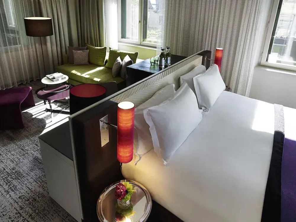 Junior-Suite mit Doppelbett und gemütlicher Sitzecke im Sofitel Munich Bayerpost