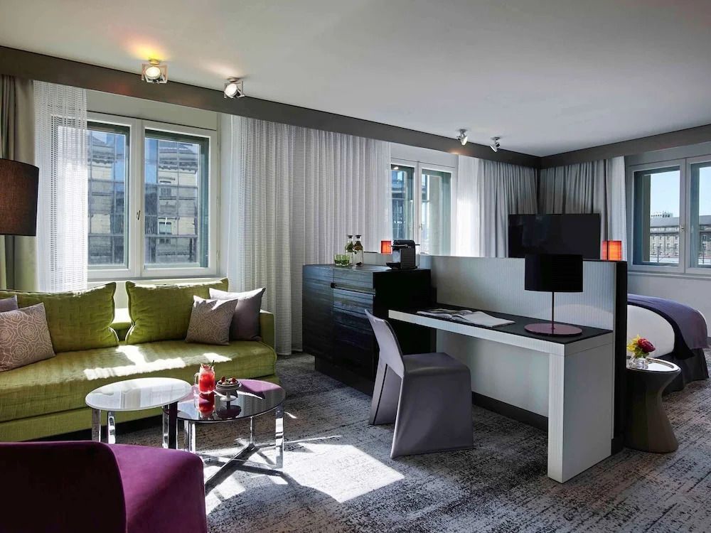Moderne Junior-Suite mit Schreibtisch und heller Sitzecke im Sofitel Munich Bayerpost