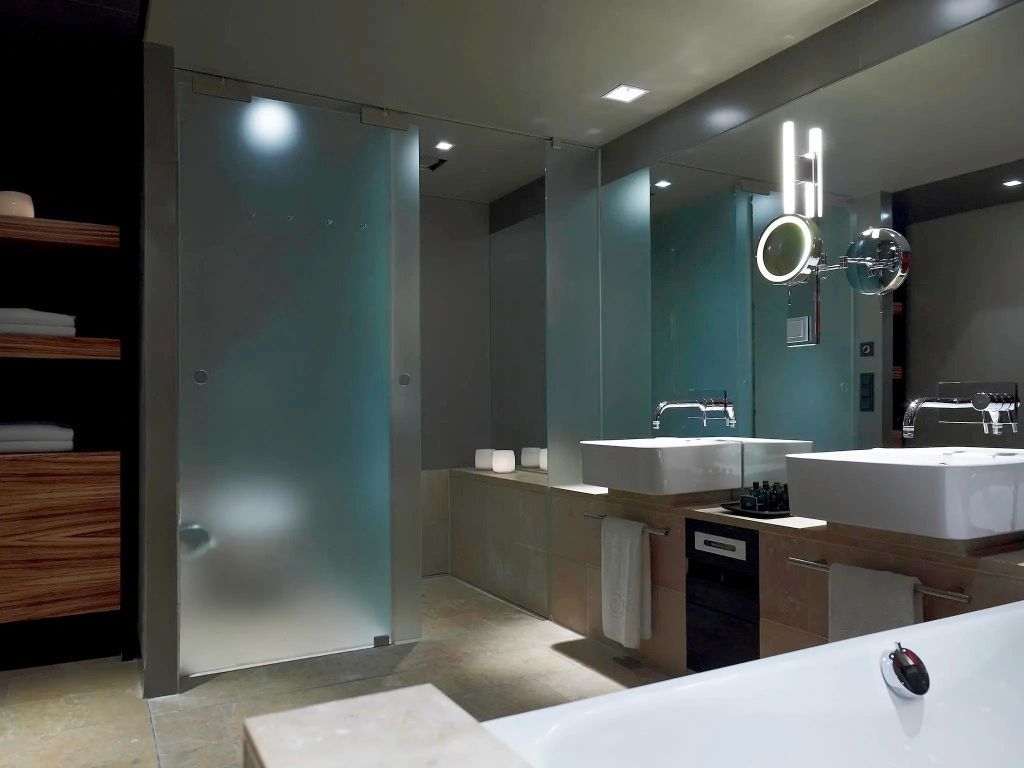 Modernes Badezimmer mit großer Spiegelfläche und stilvoller Beleuchtung