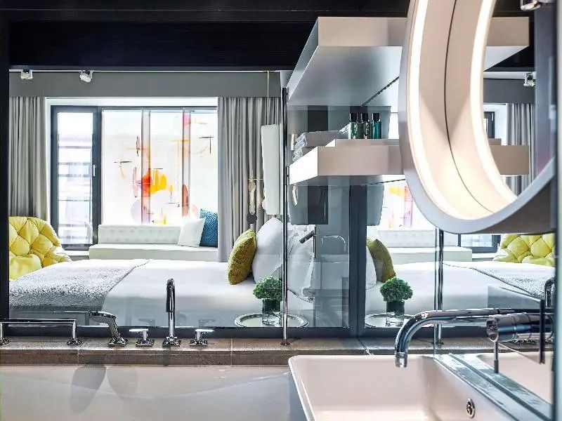 Blick vom Badezimmer in das Zimmer mit stilvoller Dekoration und Pflegeprodukten
