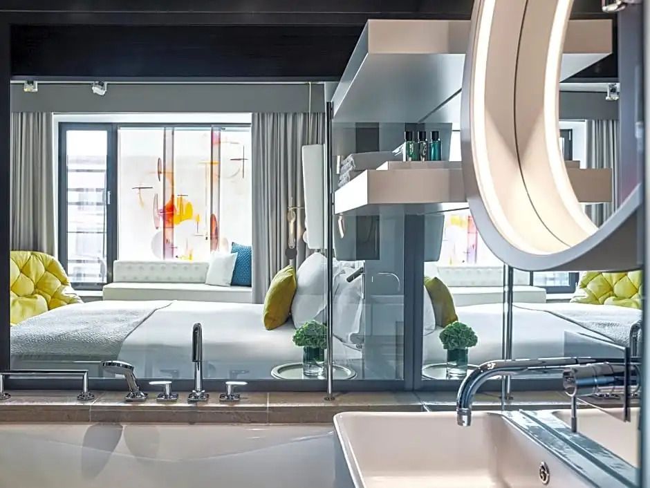 Blick vom Bad ins luxuriöse Zimmer mit Doppelbett und eleganten Details