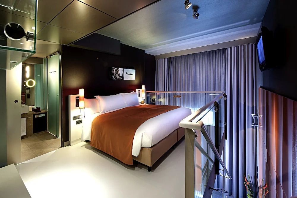 Moderne Schlafzimmeransicht mit Doppelbett und gemütlicher Beleuchtung in der Suite