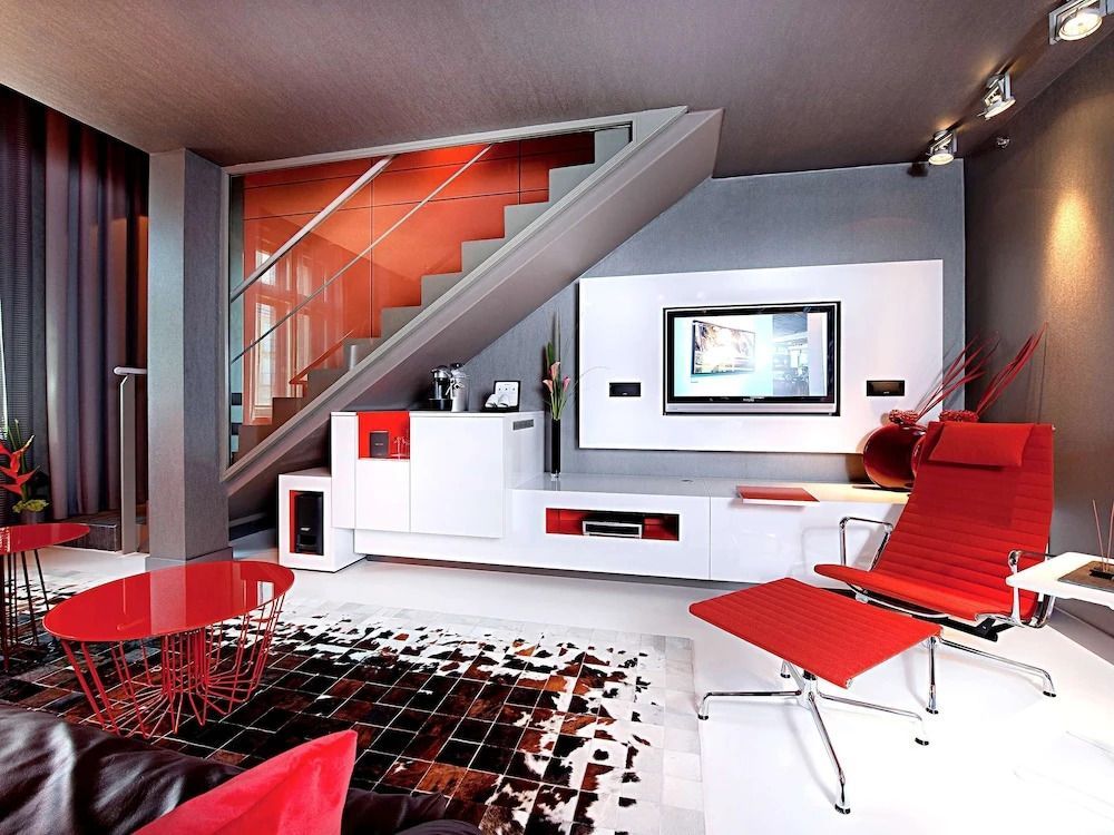 Moderne Wohnzimmereinrichtung mit treppe und roten Akzenten in der Suite