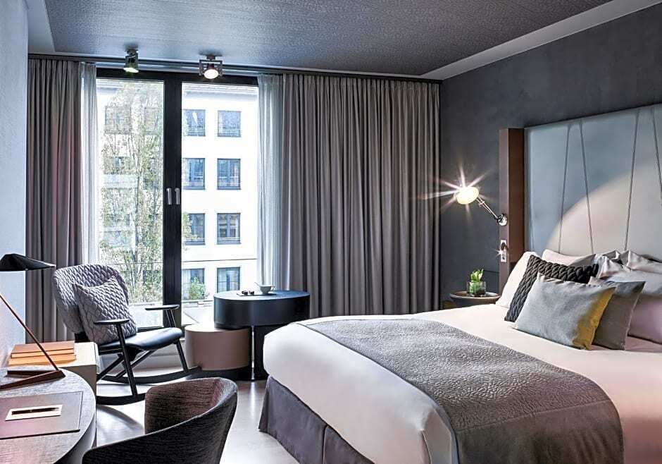 Helles Superior Doppelzimmer mit Doppelbett und großen Fenstern im Sofitel Munich Bayerpost