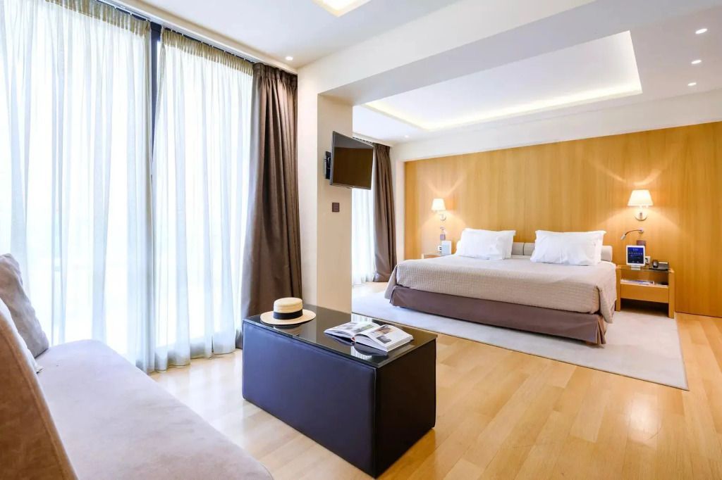 Helles Zimmer mit großem Bett und Fensterfront in der Deluxe Riviera Dreier Suite