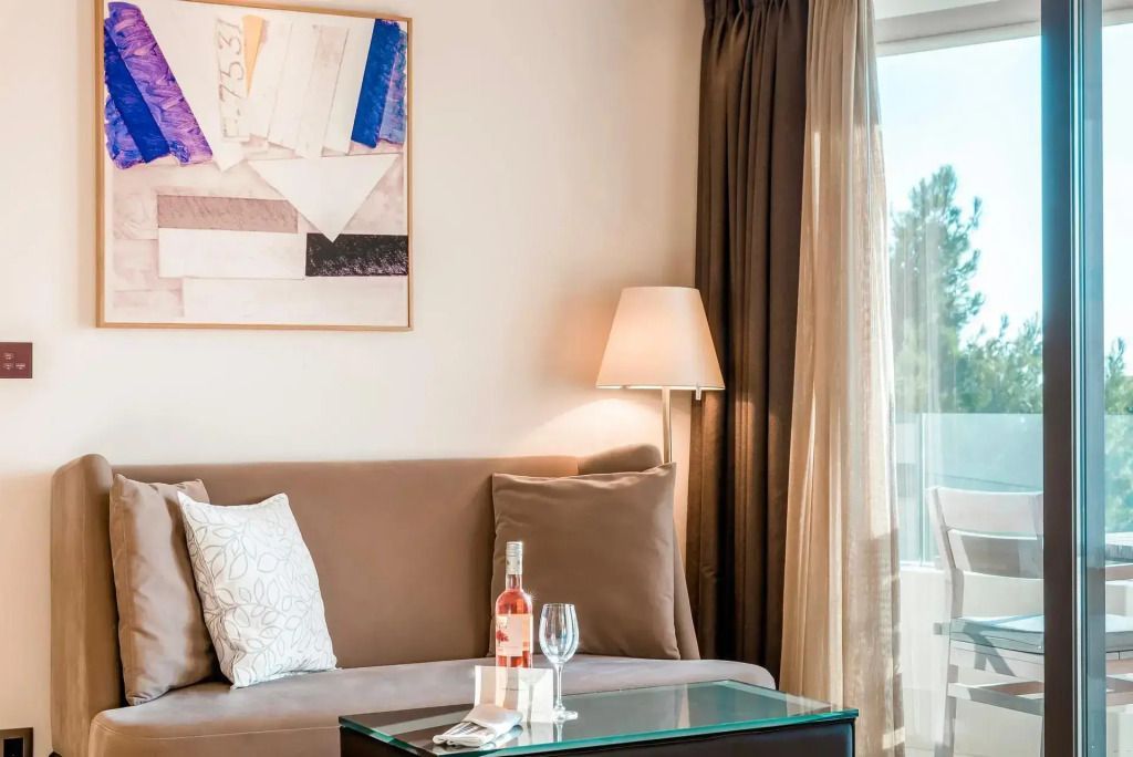 Gemütliche Sitzecke mit Sofa und Weinglas in einer Luxussuite