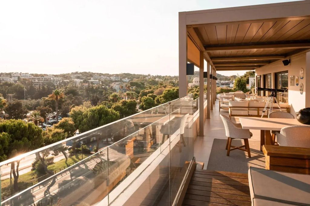 Große Dachterrasse mit Glasgeländer und gemütlichen Sitzbereichen.