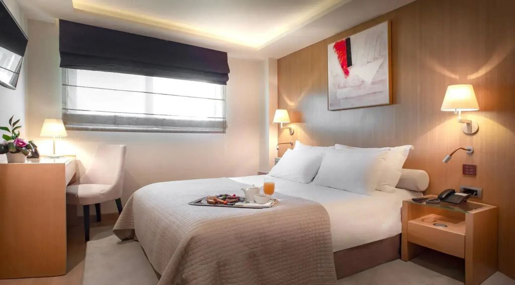 Helles Gästezimmer mit Doppelbett und modernem Kunstwerk an der Wand