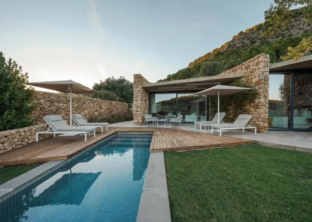 Privater Pool mit Liegestühlen und mediterrane Steinfassade in der Suite Doppelhaus