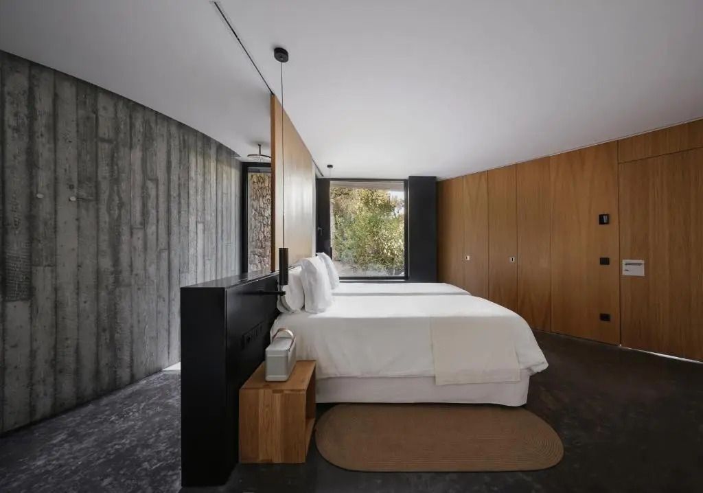 Elegantes Schlafzimmer mit Holzwänden und Bett mit strahlend weißen Laken