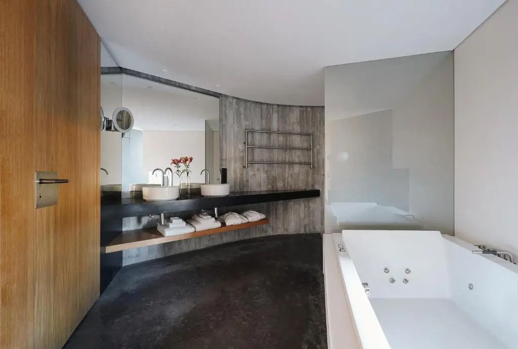 Luxuriöses Badezimmer mit Whirlpool und großen Spiegeln
