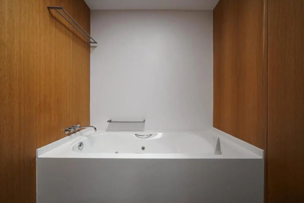 Geräumige Badewanne in einem Raum mit Holzwänden