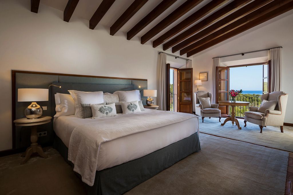 Luxuriöses Schlafzimmer mit Holzbalkendecke und Blick nach draußen