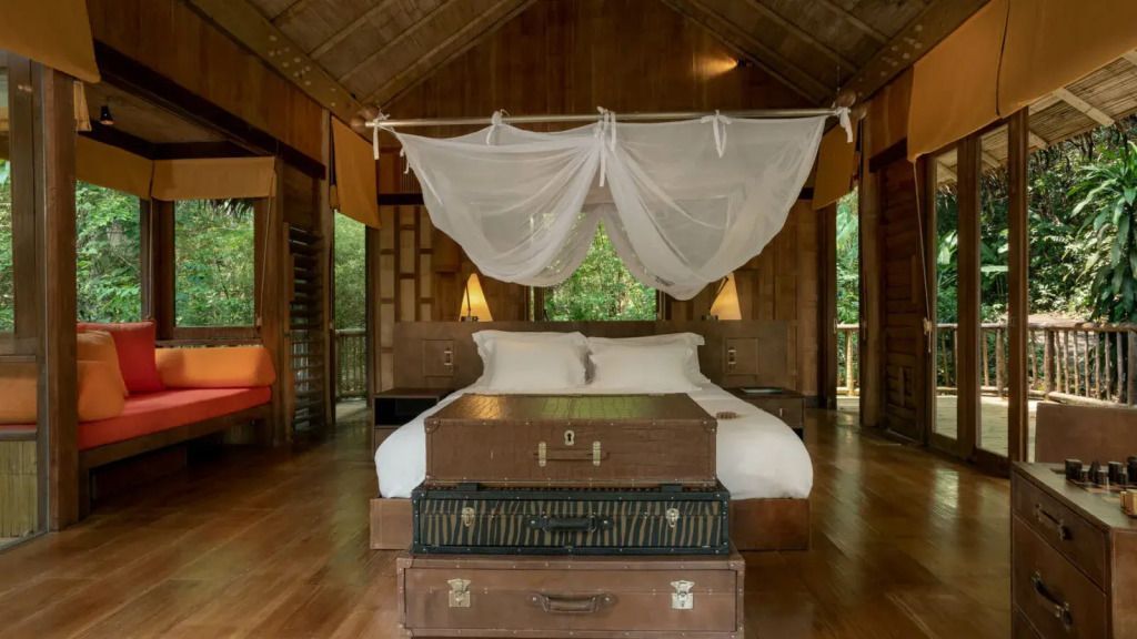 Luxus-Schlafzimmer mit Holzdekor, Himmelbett und Blick auf den Wald