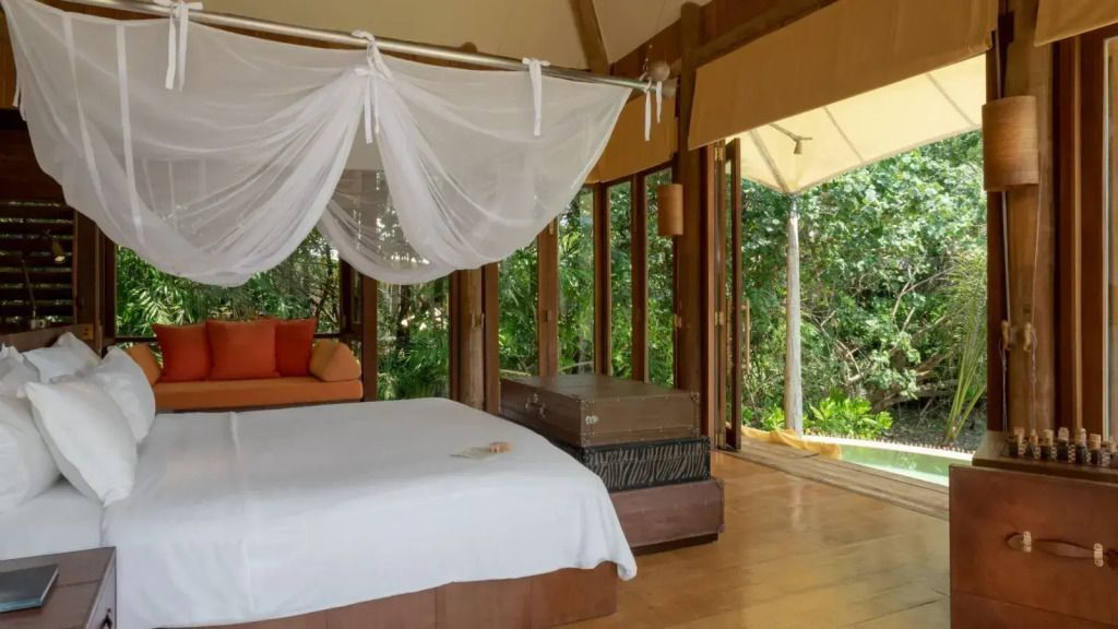Gemütliches Schlafzimmer mit Himmelbett und Terrasse im Grünen.