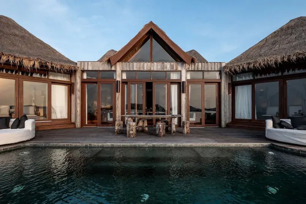 Villa mit Glasfronten und privatem Pool bei Sonnenuntergang