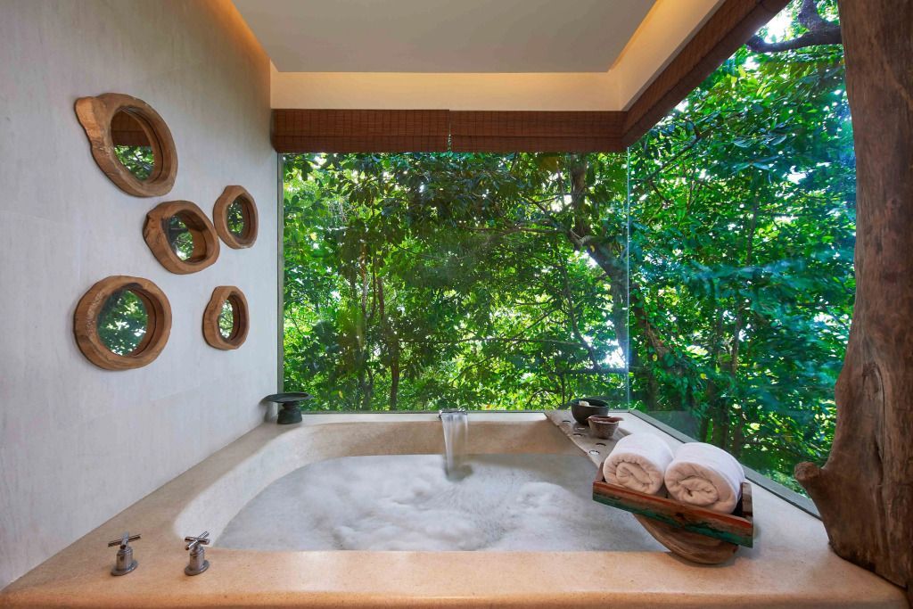 Geräumiges Badezimmer mit großer Badewanne und Blick ins Grüne.
